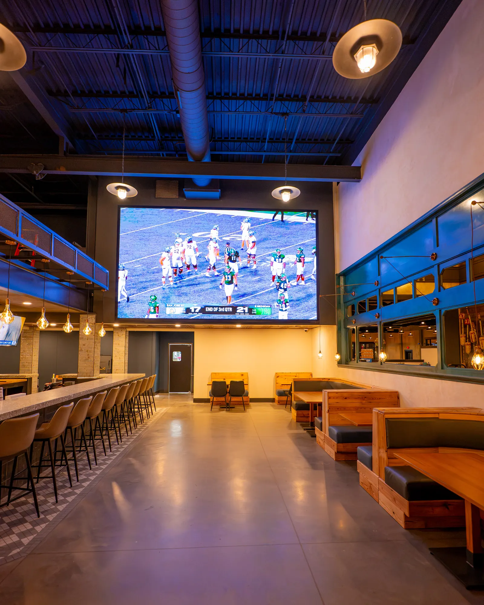 Football on Big Fish's large indoor LED video wall, with bar and booth seating below