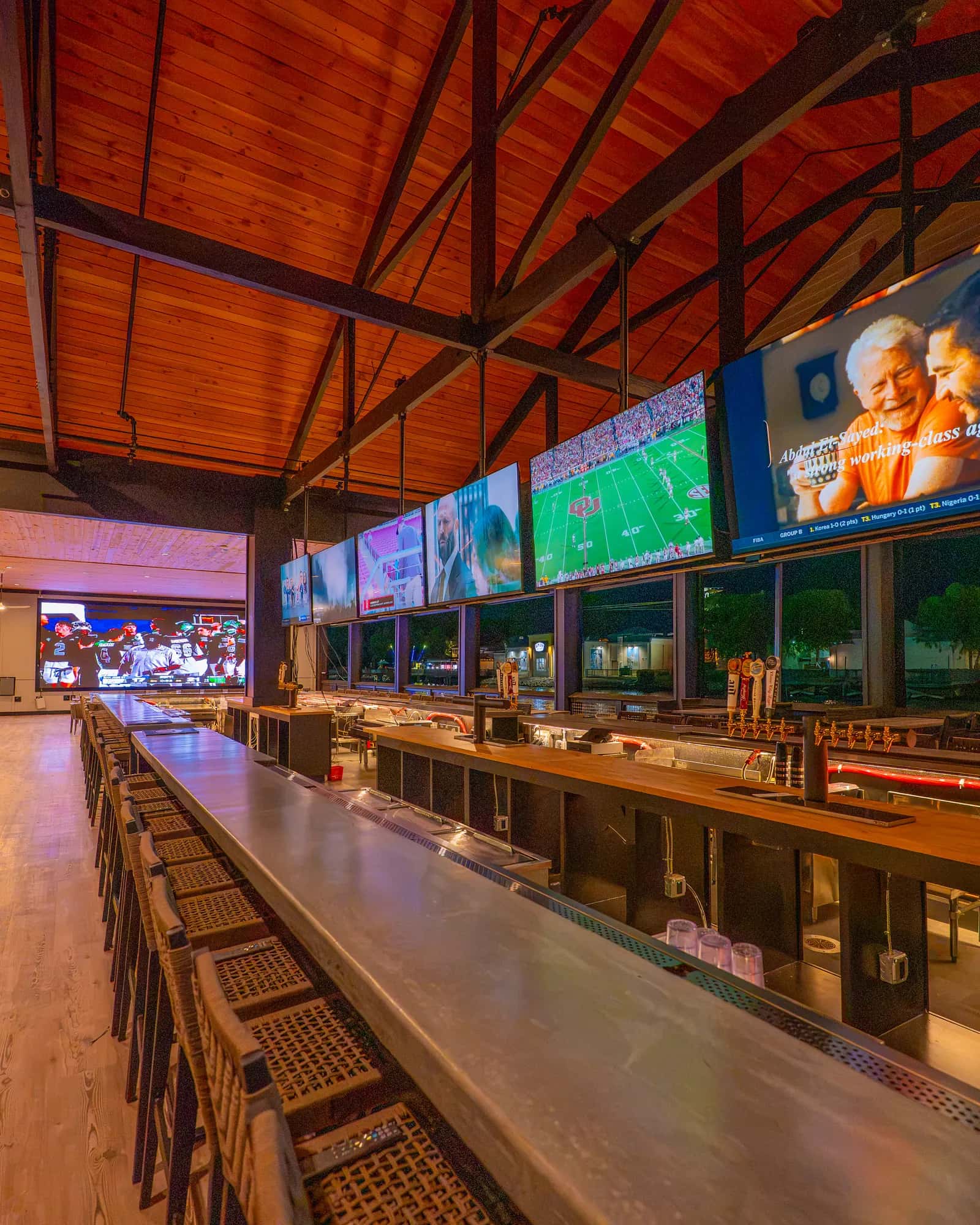 Big Fish's covered outside bar with a row of TVs and a large LED panel